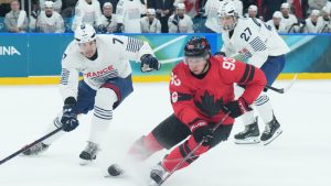 Mitch Marner (93) of Team Canada controls the puck as Pierre Crinon (7) of Team France defends during first period Olympic hockey action at the 2026 Milan Cortina Winter Olympics in Milan, Italy on Sunday Feb. 15, 2026. (Nathan Denette/CP)