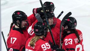 Canada's Blayre Turnbull, center, is congratulated after scoring a goal against Germany during the third period of a women's ice hockey quarterfinal match at the 2026 Winter Olympics, in Milan, Italy, Saturday, Feb. 14, 2026. (AP Photo/Carolyn Kaster)
