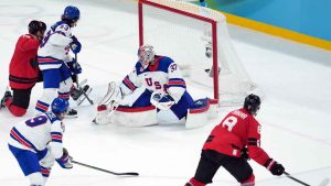 Canada's Cale Makar (8) scores on United States goalie Connor Hellebuyck (37) during the second period of the men's gold medal hockey game at the 2026 Winter Olympics, in Milan. (Darryl Dyck/THE CANADIAN PRESS)