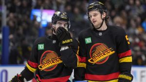 Vancouver Canucks' Conor Garland, left, and Teddy Blueger talk before a faceoff during the third period of an NHL hockey game against the Washington Capitals, in Vancouver, on Wednesday, January 21, 2026. (Darryl Dyck/CP)