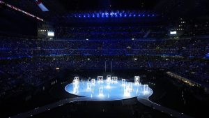 Volunteers take their place on the round centre stage during the opening ceremony at the Milan Cortina Winter Olympics, in Milan, Friday, Feb. 6, 2026. (Nathan Denette/THE CANADIAN PRESS)