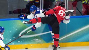 Canada's Connor McDavid (97) checks United States' Jack Eichel (9) during the first period of the men's gold medal hockey game at the 2026 Winter Olympics, in Milan, on Sunday, Feb. 22, 2026. (Darryl Dyck/CP)