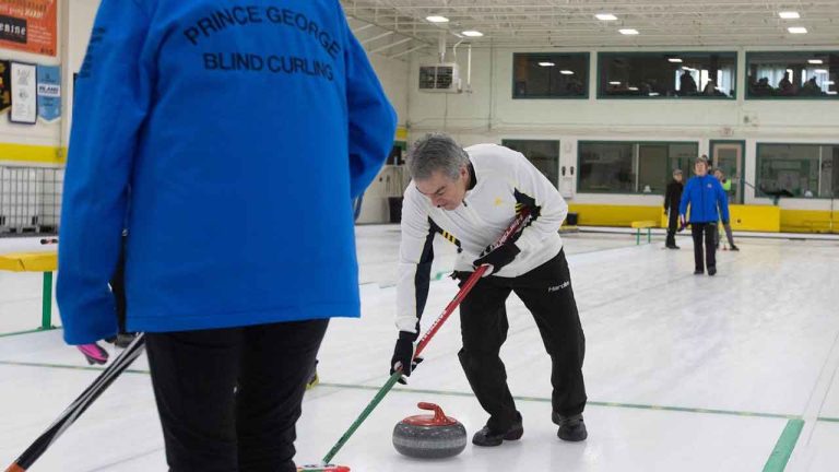 Victor Santos of Team Prince George sweeps a rock during the Canadian Vision Impaired Curling Championship. (Jason Franson/THE CANADIAN PRESS)