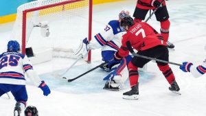 Canada's Devon Toews (7) misses the net as United States goalie Connor Hellebuyck (37) tries to make the save during the third period of the men's gold medal hockey game at the 2026 Winter Olympics, in Milan, on Sunday, Feb. 22, 2026. (Darryl Dyck/CP)