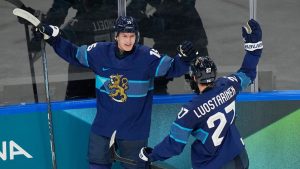 Finland's Anton Lundell, left, celebrates with Finland's Eetu Luostarinen after scoring his sides second goal during a preliminary round match of men's ice hockey between Finland and Sweden at the 2026 Winter Olympics, in Milan, Italy, Friday, Feb. 13, 2026. (Hassan Ammar/AP)