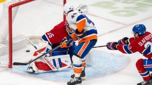 New York Islanders' Jean-Gabriel Pageau (44) scores on Montreal Canadiens goaltender Samuel Montembeault (35) during overtime NHL hockey action in Montreal on Thursday, Feb. 26, 2026. (Christinne Muschi/CP)