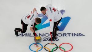 Canada's Ben Hebert, and Marc Kennedy sweep ahead of a stone during a men's curling round robin match against Switzerland at the 2026 Winter Olympics, in Cortina d'Ampezzo, Italy, Saturday, Feb. 14, 2026. (David J. Phillip/AP Photo)