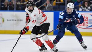 Canada defender Claire Thompson (42) shields the puck from United States forward Alex Carpenter during the second period of a Rivalry Series women's hockey game, Saturday, Nov. 8, 2025, in Buffalo, N.Y. (Adrian Kraus/AP Photo)