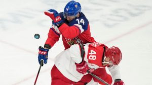 Czechia's Filip Chlapik (14) and Denmark's Nicholas Jensen (48) battle for the puck during the first period of a men's ice hockey qualification playoff game at the 2026 Winter Olympics, in Milan, Italy, Tuesday, Feb. 17, 2026. (Hassan Ammar/AP Photo)