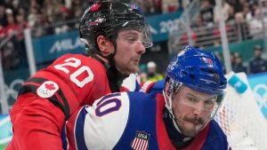 Canada's Thomas Harley (20) and United States' JT Miller (10) during a men's ice hockey gold medal game between Canada and the United States at the 2026 Winter Olympics, in Milan, Italy, Sunday, Feb. 22, 2026. (Hassan Ammar/AP Photo)