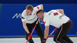 Canada's Ben Hebert and Marc Kennedy in action during the men's curling round robin session against Czechia, at the 2026 Winter Olympics, in Cortina d'Ampezzo, Italy, Monday, Feb. 16, 2026. (AP Photo)