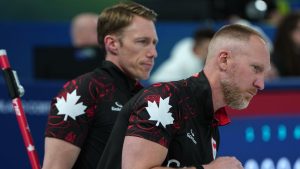 Canada's Marc Kennedy (left) and Brad Jacobs in action during the men's curling round robin session against Sweden, at the 2026 Winter Olympics, in Cortina d'Ampezzo, Italy, Friday, Feb. 13, 2026. (Misper Apawu/AP Photo)