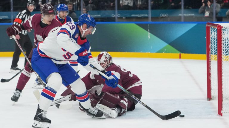 United States' Brock Nelson scores his sides second goal past Latvia's goalkeeper Elvis Merzlikins during a preliminary round match of men's ice hockey between Latvia and the United States at the 2026 Winter Olympics, in Milan, Italy, Thursday, Feb. 12, 2026. (Carolyn Kaster/AP)