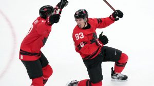 Canada's Mitch Marner (93) and Macklin Celebrini (17) celebrate after Marner scored the winning goal during the overtime period of a men's ice hockey quarterfinal game between Canada and Czechia at the 2026 Winter Olympics, in Milan, Italy, Wednesday, Feb. 18, 2026. (AP Photo/Carolyn Kaster)