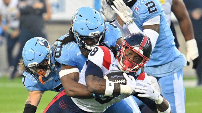Toronto Argonauts linebacker Wynton McManis, centre left, tackles Montreal Alouettes running back Stevie Scott III (8) during first half CFL football action in Toronto Friday, Sept. 19, 2025. (Jon Blacker/CP)