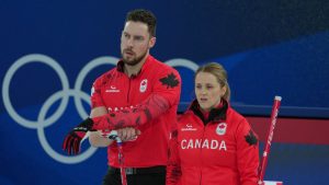 Canada's Brett Gallant, left, and Jocelyn Peterman look on during the mixed doubles round robin phase of the curling competition against the Czech Republic at the 2026 Winter Olympics, in Cortina d'Ampezzo, Italy, Wednesday, Feb. 4, 2026. (Misper Apawu/AP Photo)