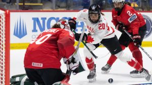 Canada's Sarah Nurse (20) drives the net against Switzerland goaltender Andrea Brandli (20) during second period hockey action at the IIHF Women's World Hockey Championship in Utica, N.Y., Friday, April 5, 2024. (Christinne Muschi/THE CANADIAN PRESS)