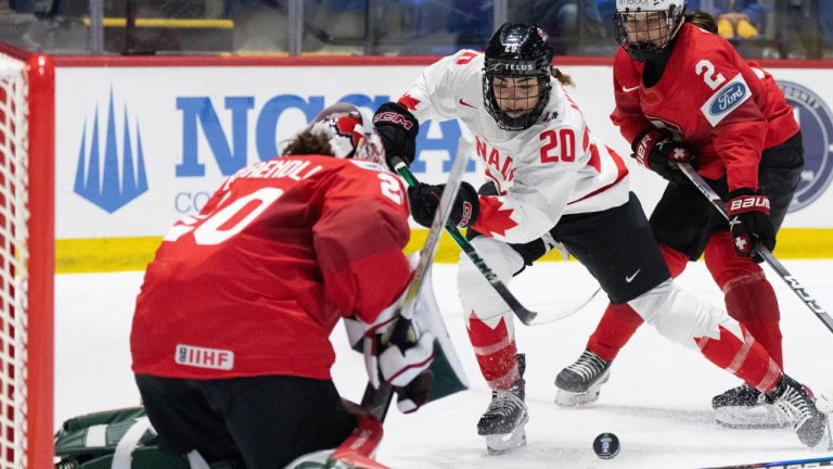 Canada's Sarah Nurse (20) drives the net against Switzerland goaltender Andrea Brandli (20) during second period hockey action at the IIHF Women's World Hockey Championship in Utica, N.Y., Friday, April 5, 2024. (Christinne Muschi/THE CANADIAN PRESS)