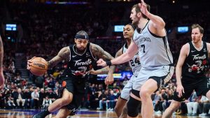 Toronto Raptors' Brandon Ingram (3) drives through San Antonio Spurs' Devin Vassell (24), centre, and Luke Kornet (7) during first half NBA basketball action in Toronto, on Wednesday, Feb. 25, 2026. (Sammy Kogan/CP)