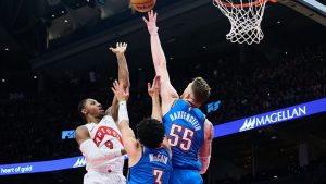 Toronto Raptors' RJ Barrett (9) is stopped at the net by Oklahoma City Thunder's Jared McCain (3), centre, and Isaiah Hartenstein (55) during second half NBA basketball action in Toronto, on Tuesday, Feb. 24, 2026. (Sammy Kogan/CP)