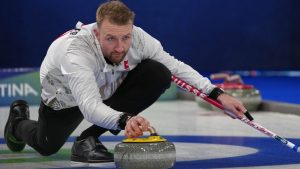 Switzerland's Yannick Schwaller in action during the men's curling round robin session against Britain, at the 2026 Winter Olympics, in Cortina d'Ampezzo, Italy, Sunday, Feb. 15, 2026. (Misper Apawu/AP Photo)