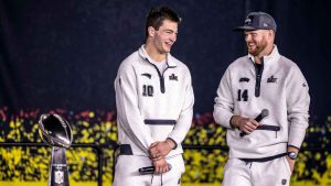 New Englad Patriots quarterback Drake Maye, left, and Seattle Seahawks quarterback Sam Darnold, right, smile on stage with the Lombardi Trophy during the NFL Super Bowl Opening Night, Monday, Feb. 2, 2026, in San Jose, Calif., ahead of the Super Bowl 60 football game between the New England Patriots and the Seattle Seahawks. (Carlos Avila Gonzalez/AP)