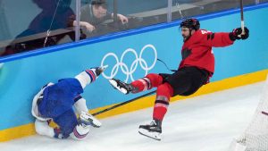 Canada's Tom Wilson (43) checks United States' Dylan Larkin (21) during the first period of the men's gold medal hockey game at the 2026 Winter Olympics, in Milan. (Darryl Dyck/THE CANADIAN PRESS)