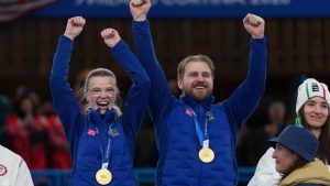 Sweden's Isabella Wrana and Rasmus Wrana celebrate on the podium after winning the gold medal match of the mixed doubles curling at the 2026 Winter Olympics, in Cortina d'Ampezzo, Italy, Tuesday, Feb. 10, 2026. (Misper Apawu/AP Photo)