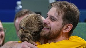Sweden's Isabella Wrana and Rasmus Wrana hug during the mixed doubles round robin phase of the curling competition against Canada, at the 2026 Winter Olympics, in Cortina d'Ampezzo, Italy, Sunday, Feb. 8, 2026. (Fatima Shbair/AP Photo)