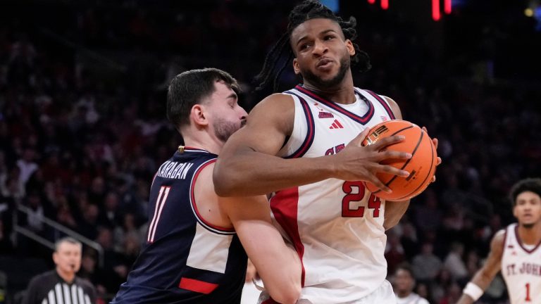 St. John's forward Zuby Ejiofor (24) drives past UConn forward Alex Karaban (11) during the first half of an NCAA college basketball game in the championship of the Big East tournament, Saturday, March 14, 2026, in New York. (AP Photo/Yuki Iwamura)