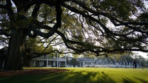 A waiter wipes down the chairs outside the clubhouse at Augusta National before a practice day at the Masters golf tournament on Tuesday, April 6, 2021, in Augusta, Ga. (AP Photo/David J. Phillip)