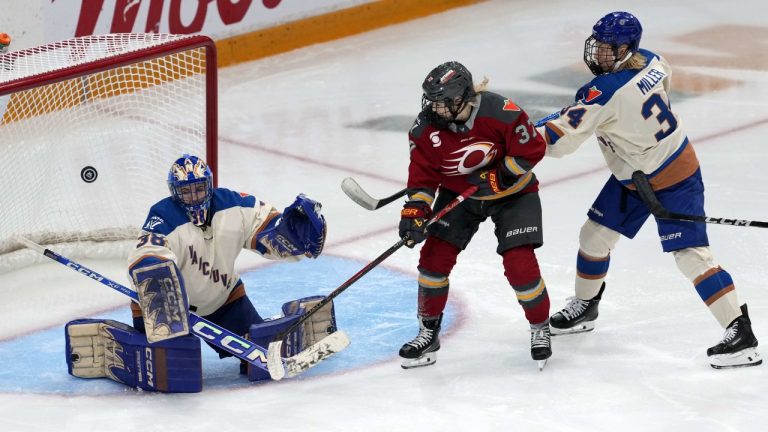 Ottawa Charge's Rebecca Leslie (37) and Vancouver Goldeneyes' Hannah Miller (34) watch the puck as it bounces in front of goaltender Emerance Maschmeyer (38)  during third period PWHL hockey action in Ottawa, on Wednesday, Nov. 26, 2025. THE CANADIAN PRESS/Justin Tang