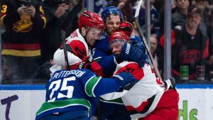 Vancouver Canucks' Elias Pettersson (25), Teddy Blueger (53), Carolina Hurricanes' Sean Walker (26) and Andrei Svechnikov (37) fight during the second period of an NHL hockey game in Vancouver, on Wednesday, March 4, 2026. (Ethan Cairns/CP)