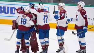 Colorado Avalanche players, from left, centre Jack Drury (18), centre Parker Kelly (17), centre Ross Colton (20) and defenceman Josh Manson (42) surround goaltender Scott Wedgewood, second from left, after they beat the Dallas Stars in an overtime shootout of an NHL hockey game Friday, March 6, 2026, in Dallas. (Julio Cortez/AP)