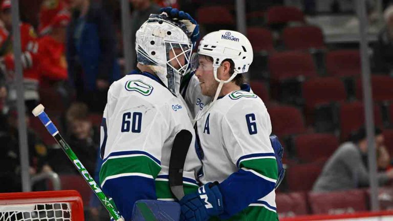 Vancouver Canucks goalie Nikita Tolopilo (60) celebrates with teammate Brock Boeser (6) after defeating the Chicago Blackhawks in an NHL hockey game in Chicago, Friday, March 6, 2026. (Paul Beaty/AP)