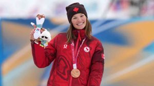 Brittany Hudak, of Canada, poses on the podium after winning the bronze medal in the cross country skiing women's 10Km interval start classic standing final at the 2026 Winter Paralympics, in Tesero, Italy, Wednesday, March 11, 2026. (Evgeniy Maloletka/AP)