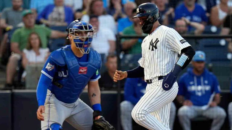 New York Yankees' Ali Sánchez, right, scores behind Toronto Blue Jays catcher Brandon Valenzuela on an RBI double by Trent Grisham during the third inning of a spring training baseball game Wednesday, March 11, 2026, in Tampa, Fla. (Chris O'Meara/AP)
