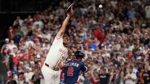 United States third baseman Alex Bregman (2) is safe at first base as Canada first baseman Josh Naylor, left, reaches for a wild throw during the third inning of a World Baseball Classic quarterfinal game, Friday, March 13, 2026, in Houston. (David J. Phillip/AP)
