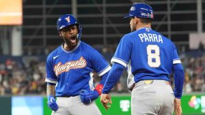 Venezuela Maikel Garcia reacts to first base coach Gerardo Parra (8) after getting on the base during the seventh inning of a World Baseball Classic semifinal game against Italy, Monday, March 16, 2026, in Miami. (Rebecca Blackwell/AP)