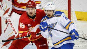St. Louis Blues' Pius Suter, right, is checked by Calgary Flames' Hunter Brzustewicz during first period NHL hockey action in Calgary on Wednesday, March 18, 2026. (Jeff McIntosh/CP)