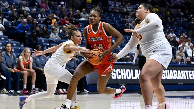 Syracuse center Uche Izoje, center, splits the defense of Iowa State guard Jada Williams, left, and center Audi Crooks, right, during the second half in the first round of the NCAA college basketball tournament, Saturday, March 21, 2026, in Storrs, Conn. (AP Photo/Jessica Hill)
