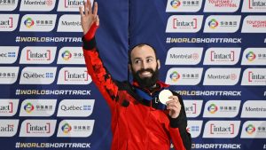 Steven Dubois of Canada waves to the crowd as he holds up his gold medal following the final of the 500m race at the ISU World Short Track Speed Skating Championships in Montreal, Saturday, March 14, 2026. (Graham Hughes/CP)