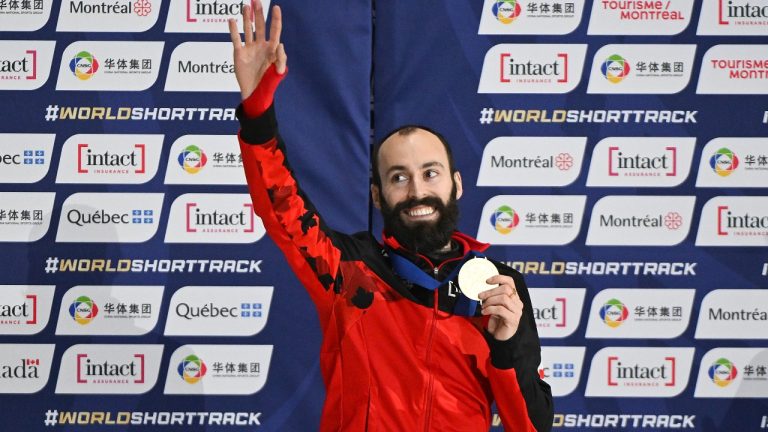 Steven Dubois of Canada waves to the crowd as he holds up his gold medal following the final of the 500m race at the ISU World Short Track Speed Skating Championships in Montreal, Saturday, March 14, 2026. (Graham Hughes/CP)