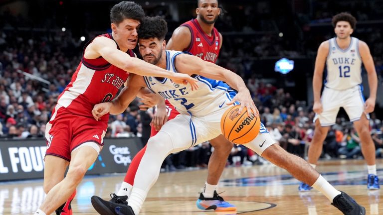 Duke guard Cayden Boozer (2) drives as St. John's guard Dylan Darling (0) defends during the second half in the Sweet 16 of the NCAA college basketball tournament, Friday, March 27, 2026, in Washington. (AP Photo/Stephanie Scarbrough)