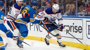 Edmonton Oilers' Connor McDavid (97) skates with the puck while under pressure from St. Louis Blues' Robert Thomas (18) during the first period of an NHL hockey game Friday, March 13, 2026, in St. Louis. (Scott Kane/AP)