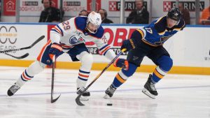 Edmonton Oilers' Leon Draisaitl (29) and St. Louis Blues' Cam Fowler (17) chase after a loose puck during the third period of an NHL hockey game Monday, Nov. 3, 2025, in St. Louis. (Jeff Roberson/AP)