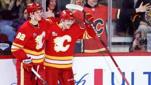 Calgary Flames C Morgan Frost, rt, celebrates with RW Matvei Gridin and fans his goal against the Vancouver Canucks during second period NHL hockey action in Calgary, Saturday, March 28, 2026. (Larry MacDougal/CP)
