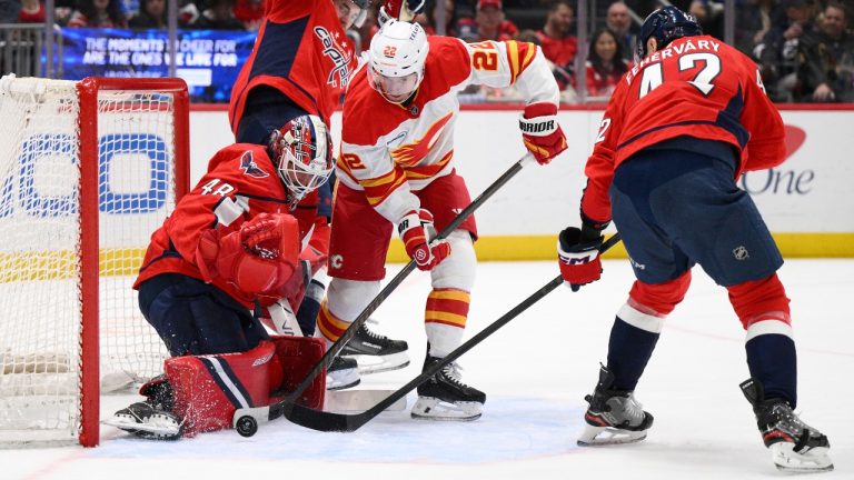 Calgary Flames centre Ryan Strome (22) battles for the puck against Washington Capitals goaltender Logan Thompson (48) and defenseman Martin Fehérváry, right, during the second period of an NHL hockey game, Monday, March 9, 2026, in Washington. (Nick Wass/AP)