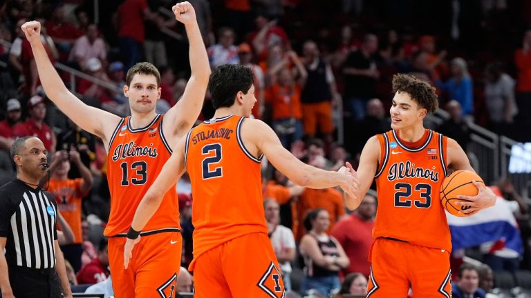 Illinois center Tomislav Ivisic (13) and guards Andrej Stojakovic (2) and Keaton Wagler (23) celebrate after defeating Houston in the Sweet 16 of the NCAA college basketball tournament Friday, March 27, 2026, in Houston. (Ashley Landis/AP)