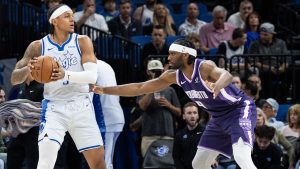 Orlando Magic forward Paolo Banchero (5) holds the ball against Sacramento Kings forward Precious Achiuwa (9) during the first half of an NBA basketball game, Thursday, March 26, 2026, in Orlando, Fla. (AP Photo/Willie J. Allen Jr.)